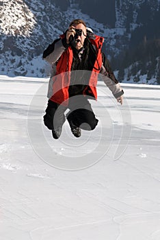 Main in red jumping on winter lake