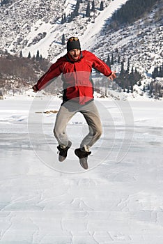 Main in red jumping on winter lake