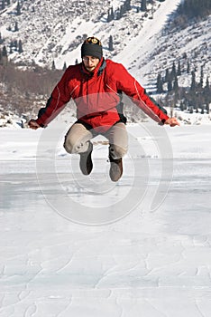 Main in red jumping on winter lake