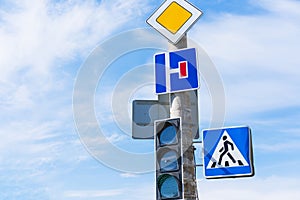 Main Road sign and a No Turn Allowed sign near sidewalk and traffic light