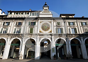 Main square in Brescia with belltower and ancient clock, Italy
