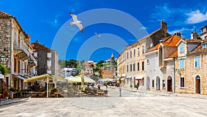 Main square in old medieval town Hvar with seagull`s flying over. Hvar is one of most popular tourist destinations in Croatia in photo