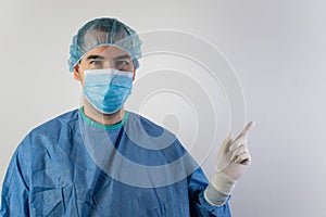 The main subject is out of focus, young male surgeon medical gloves show point