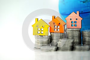 Mainature people standing with coins stack and home.  Home financial investment Concept