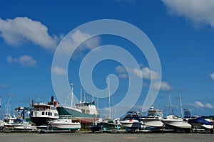 Maine boat yard under clouds in blue sky, early fall, with many boats