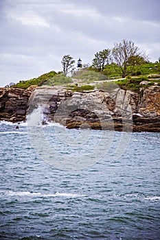 Maine lighthouse Portland Head Light behind rocky cliff on Atlantic Ocean