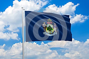 Maine national flag waving in the wind on clouds sky. High quality fabric. International relations concept