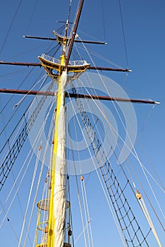 Mainmast of big sailboat with blue sky in background