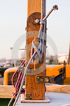 A mainsail halyard is attached on a wooden cleat