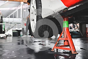 Maintenance car. Jacking up a car for changing tyre in garage