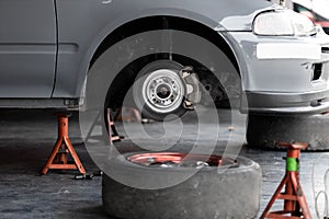 Maintenance car. Jacking up a car for changing tyre in garage