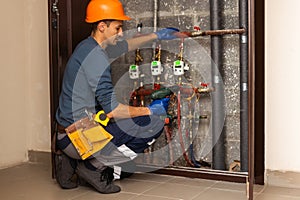 Maintenance engineer checking technical data of heating system equipment in a boiler room. Plumber installing pressure