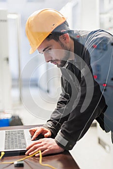 Maintenance engineer inspect relay protection system with laptop