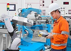 Maintenance engineer programing automated robotic at industry 4.