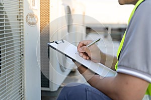 maintenance engineer works on the roof of factory. contractor inspect compressor system and plans installation of air condition