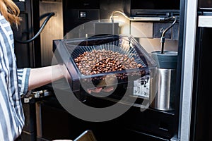 Maintenance of modern coffee machines. Loading coffee beans.