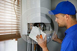 Maintenance and repair service engineer working with house gas heating boiler