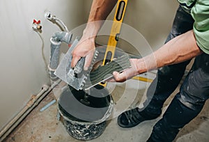 Maintenance repair works renovation in the flat. Restoration indoors in the flat. Man is priming a surface with a brush and palett