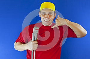 Maintenance and repairing concept. Mechanic or plumber with gas key in hands. Man holds wrench tools near face. Call the repairman
