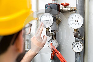 Maintenance - technician checking heating pressure meters photo