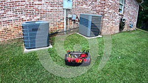 Maintenance tool bag in front of home HVAC Air Conditioner units