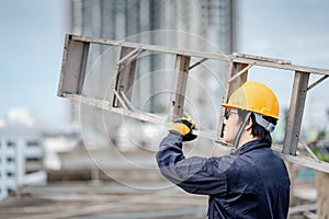 Maintenance worker man carrying aluminium ladder