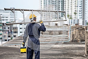 Maintenance worker man carrying aluminium ladder