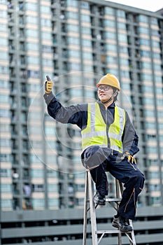 Maintenance worker showing thumb up on ladder