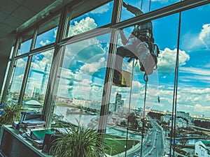 A maintenance workers cleaning windows on high rise