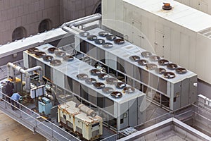 Maintenance Workers on Large City Building HVAC Electrical Rooftop Packaged Units.