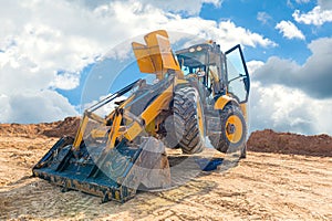 Maintenance of yellow excavator on a construction site against blue sky. repearing wheel loader at sandpit during earthmoving