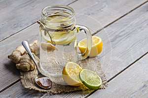 A maison jar with ginger and lemon tea on the wooden background