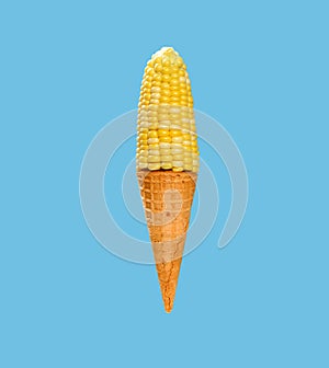 maize and empty cone shaped like an ice cream cone on blue background at square composition photo