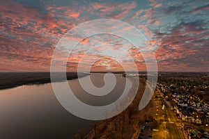 A majestic aerial shot of the flowing waters of the Mississippi river with blue sky at sunset and a view of the homes