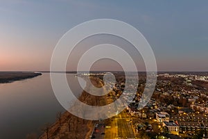 A majestic aerial shot of the flowing waters of the Mississippi river with blue sky at sunset and a view of the homes
