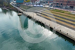 A majestic aerial shot of a still green waters of the Cumberland River with a view of the grassy staircases on the shore