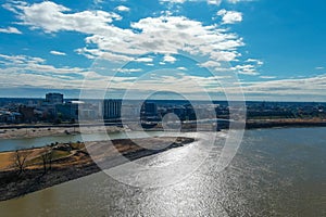 A majestic aerial shot of the vast flowing waters of the Mississippi river with a view of the skyscrapers and the buildings