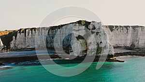 Majestic aerial view of beautiful sea coastline and epic white chalk cliff bay near small town of Etretat, Normandy.