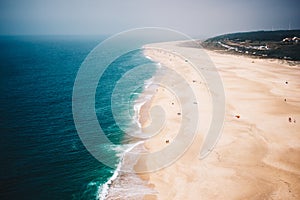 Majestic aerial view of a tropical crowded sandy beach and a beautiful blue seascape