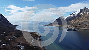 Majestic blue fjord surrounded by mighty mountains on the island of senja in the small fishing village of Grunnfarnes, northern No