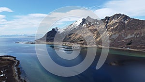 Majestic blue fjord surrounded by mighty mountains on the island of senja in the small fishing village of Grunnfarnes, northern No