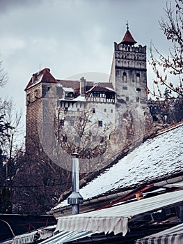 Majestic Bran castle, Romania visible in the distance, shrouded in a blanket of snow