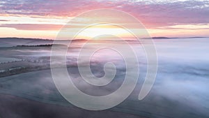 Majestic drone landscape image of sea of fog rolling across South Downs English countryside during Spring sunrise