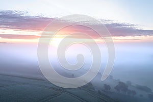 Majestic drone landscape image of sea of fog rolling across South Downs English countryside during Spring sunrise