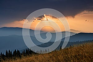 Majestic landscape of mountains at sunrise. View of the misty tops and layer hills of the mountains in the distance.