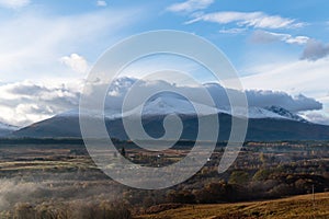 Majestic landscape view with forested fields and a snow-covered mountain range on the horizon