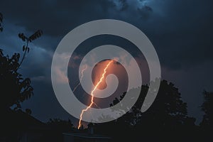 Majestic Lightning Strike Over Silhouette Trees Against Twilight Sky