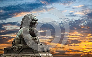 Majestic lion statue with sunset glow background