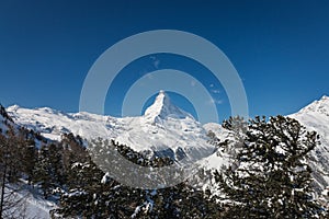 Majestic Matterhorn mountain in front of a blue sky with snow co