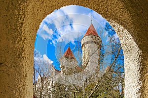Majestic medieval castle view through stone arch on a clear day